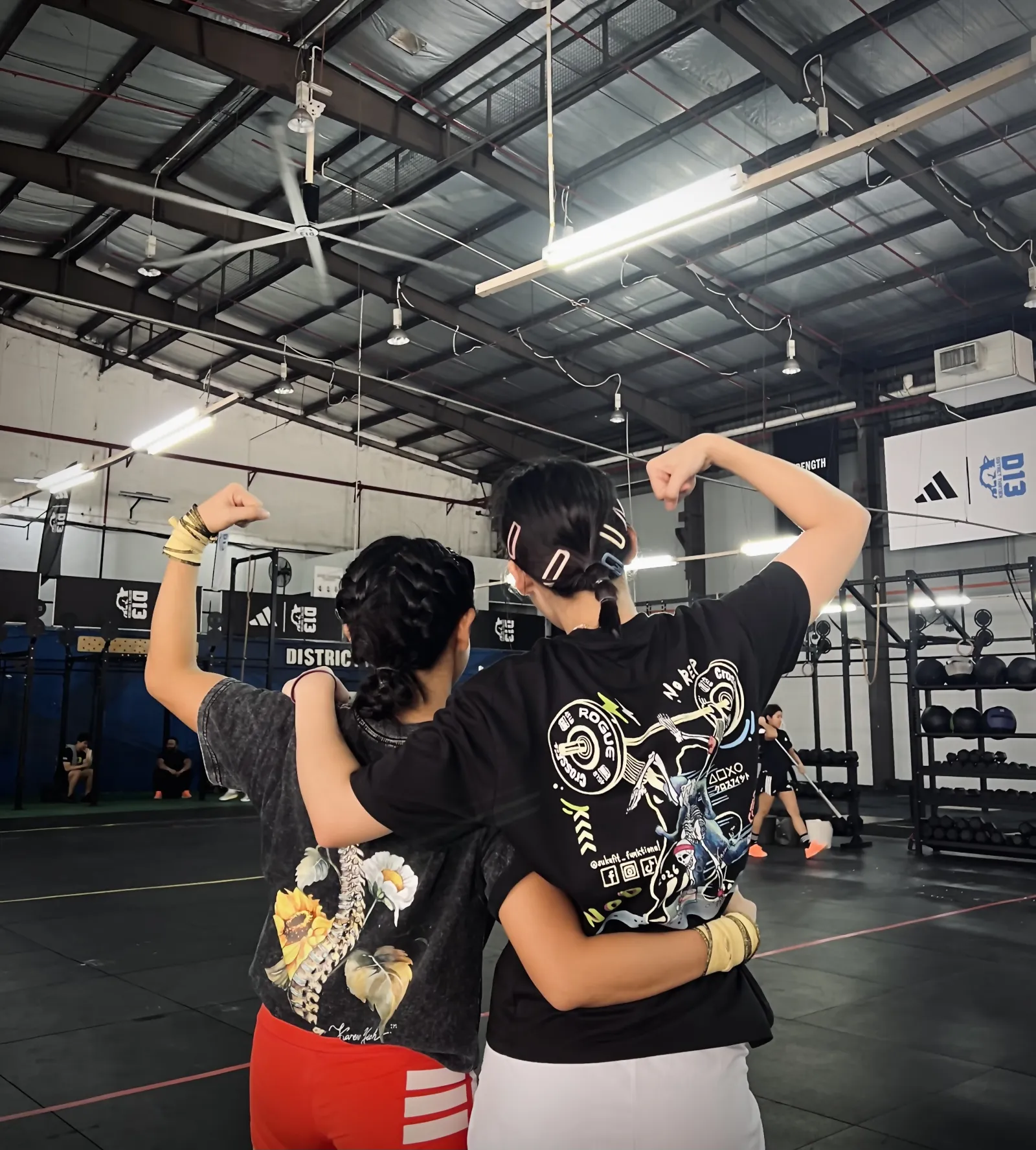Two women flexing together in the studio, celebrating strength